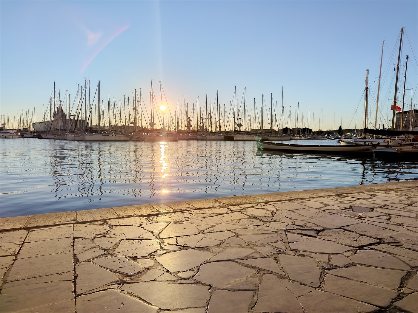 Toulon harbour at sunset, masts of moored yachts against the light